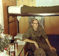 Ralph Carlton sitting on a bunk